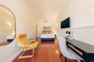 - une chambre d'hôtel avec un lit et un miroir dans l'établissement Gaslight Inn - Adults Only, à Sydney