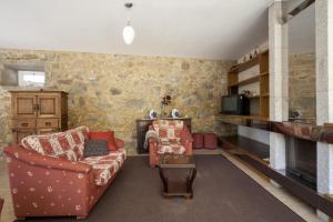 a living room with a couch and a fireplace at Casa Praia e Campo in Viana do Castelo