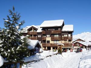 a ski lodge with a christmas tree in the snow at Résidence Soldanelles - 2 Pièces pour 6 Personnes 21 in Peisey-Nancroix