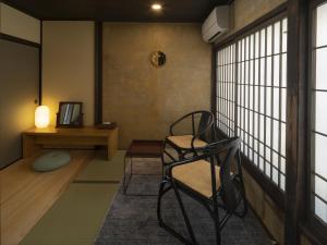 Zimmer mit einem Stuhl, einem Tisch und einem Fenster in der Unterkunft NIPPONIA HOTEL Ozu Castle Town in Ōzu