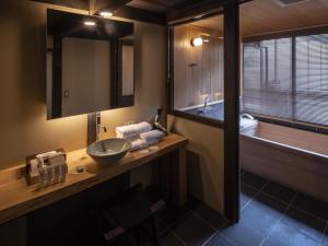 a bathroom with a sink and a bath tub at NIPPONIA HOTEL Ozu Castle Town in Ōzu