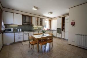 a kitchen with white cabinets and a table and chairs at Casa Praia e Campo in Viana do Castelo