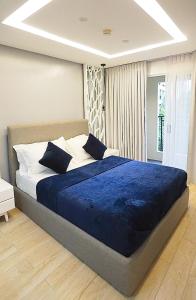 ein Schlafzimmer mit einem großen Bett mit einer blauen Decke in der Unterkunft Neroki's Crib Cozy & Luxurious Staycation! in Basak