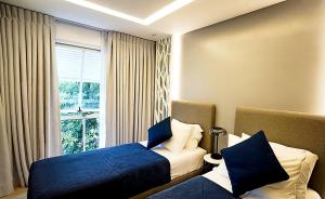 ein Hotelzimmer mit 2 Betten und einem Fenster in der Unterkunft Neroki's Crib Cozy & Luxurious Staycation! in Basak