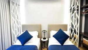 1 Schlafzimmer mit 2 Betten und blauen Kissen in der Unterkunft Neroki's Crib Cozy & Luxurious Staycation! in Basak