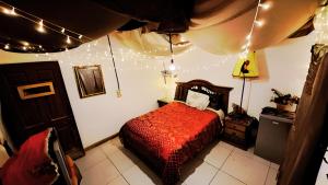 a bedroom with a bed with a red comforter at La Poza del Pato in Tarija