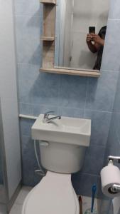 a person taking a picture of a bathroom with a toilet at Casa con calor de hogar con aire acondicionado in Neiva