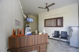Zimmer mit 2 Stühlen und einer Theke mit einem Kühlschrank in der Unterkunft Flagship 71214 Hotel Welcome Inn in Ludhiana