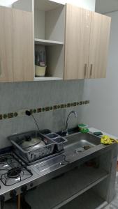 um balcão de cozinha com um lavatório e um fogão em Casa con calor de hogar con aire acondicionado em Neiva