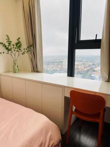 1 dormitorio con escritorio, silla y ventana en LAD Apartment & Homestay Hải Phòng - Hoàng Huy Grand Tower, en Hai Phong