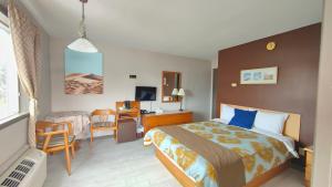 ein Hotelzimmer mit einem Bett und einem Schreibtisch in der Unterkunft Motel Le Radisson de Val-David in Val-David
