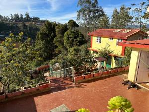 a balcony of a house with a view of a mountain at Kanjira house in Ooty