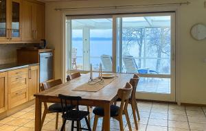 kuchnia ze stołem i krzesłami oraz duże okno w obiekcie Gorgeous Home In Vrnamo With Lake View w mieście Värnamo