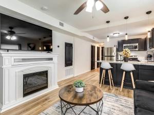 a living room with a fireplace and a kitchen at Stylish & Serene Modern Retreat in Bartlesville