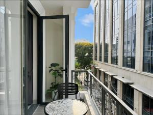 Newhome luxury apartment في مدينة هوشي منه: شرفة على طاولة وكراسي في مبنى