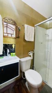 uma casa de banho com um WC, um lavatório e um chuveiro em Pousada Canto da Mata em Ipatinga