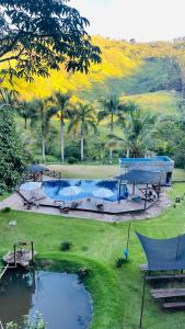um parque com duas piscinas e palmeiras em Pousada Canto da Mata em Ipatinga