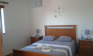 1 dormitorio con 1 cama con almohadas y toallas azules en Casa Monte Alegre, en Redinha