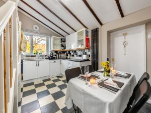 a dining room with a table and a kitchen at The Lantern Tree in Kingsteignton