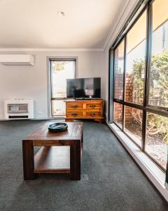 a living room with a tv and a coffee table at Spacious Coastal Gem in Port Sorell