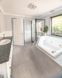 a bathroom with a large tub and a sink at Spacious Coastal Gem in Port Sorell