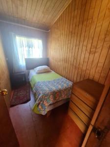 Habitación pequeña con cama y ventana en Cabaña Alejandra, en Puerto Puyuhuapi