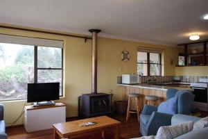 a living room with a kitchen and a stove at Jen’s Beach House - easy walk to the Ocean, Colourpatch Cafe by the river in Augusta