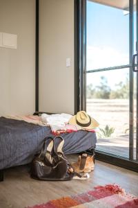 ein Schlafzimmer mit einem Bett mit Hut und Schuhen in der Unterkunft Gilgooma 