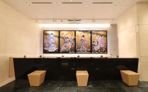 Odysis Suites Osaka Airport Hotel في إيزوميسانو: غرفة بها أربع لوحات على الحائط