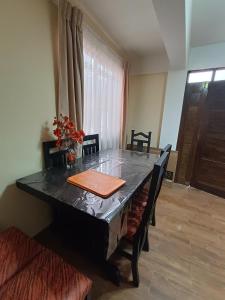 a dining room with a table with a black table top at Apartamento cómodo in Potosí