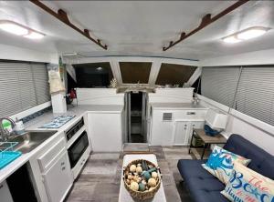 a kitchen with white cabinets and a blue couch at Dock life in Marathon