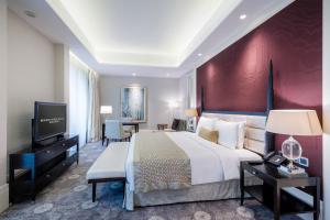 a bedroom with a large bed and a red wall at Resorts World Sentosa - Hotel Michael in Singapore