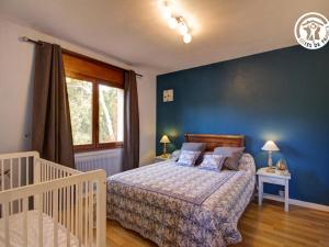 - une chambre avec un lit et un mur bleu dans l'établissement Gîte Pommiers (Loire), 7 pièces, 14 personnes - FR-1-496-35, à Pommiers-en-Forez