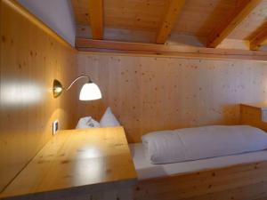 um quarto com uma cama e um candeeiro numa parede de madeira em Holiday apartment Prackfolerhof em Vols am Schlern
