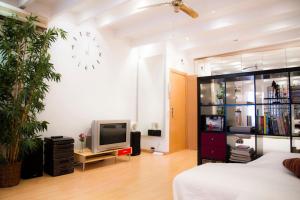 salon z łóżkiem i telewizorem w obiekcie Studio Gracia By MyRentalHost w Barcelonie