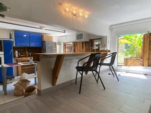 una cucina con scrivania e 2 sedie in camera di Bas de villa du Zion nature a Sainte-Anne