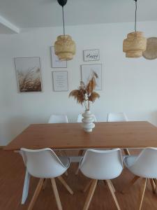 a dining room with a wooden table and white chairs at Stilvolle Ferienwohnung free parking, Space, WLAN in Niestetal