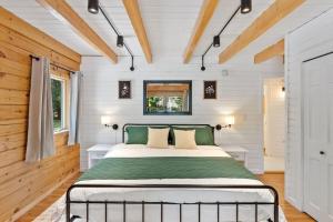 a bedroom with a bed in a room with wooden walls at Our Pondside Cabin in Westminster