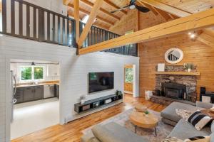 a living room with a fireplace and a wooden ceiling at Our Pondside Cabin in Westminster