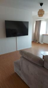 sala de estar con sofá y TV de pantalla plana en Stilvolle Ferienwohnung, en Niestetal