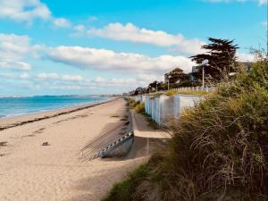 a sandy beach with a fence and the ocean at Appartement Duplex en Front de Mer avec Terrasse – Accès Direct Plage – 2 Chambres + Cabine - FR-1-361-456 in Saint-Pair-sur-Mer
