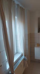 a window in a bathroom with a shower curtain at Stilvolle Ferienwohnung in Niestetal