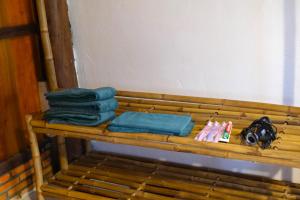 drewniana ławka z ręcznikami i innymi rzeczami w obiekcie Farmstay Sokfarm w mieście Trà Vinh