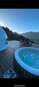 una gran bañera de hidromasaje en una terraza de madera en Divercity Luxury Glamp en Kodaikānāl