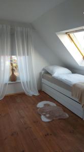 a bedroom with a bed and a window with a rug at Stilvolle Ferienwohnung in Niestetal