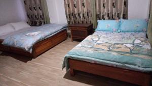 a bedroom with two beds and two night stands at Coral Homestay in Pelling