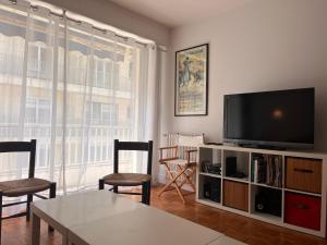 ein Wohnzimmer mit einem TV, einem Tisch und Stühlen in der Unterkunft Appartement Saint-Jean-de-Luz, 3 pièces, 5 personnes - FR-1-239-962 in Saint-Jean-de-Luz