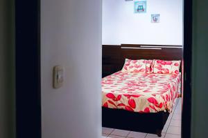 a bedroom with a bed with red flowers on it at Depto mitre in Mendoza