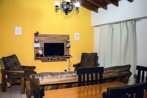 a living room with a tv and a table and chairs at Depto mitre in Mendoza