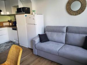 - un salon avec un canapé et un réfrigérateur blanc dans l'établissement Maison La Faute-sur-Mer, 2 pièces, 4 personnes - FR-1-476-203, à La Faute-sur-Mer